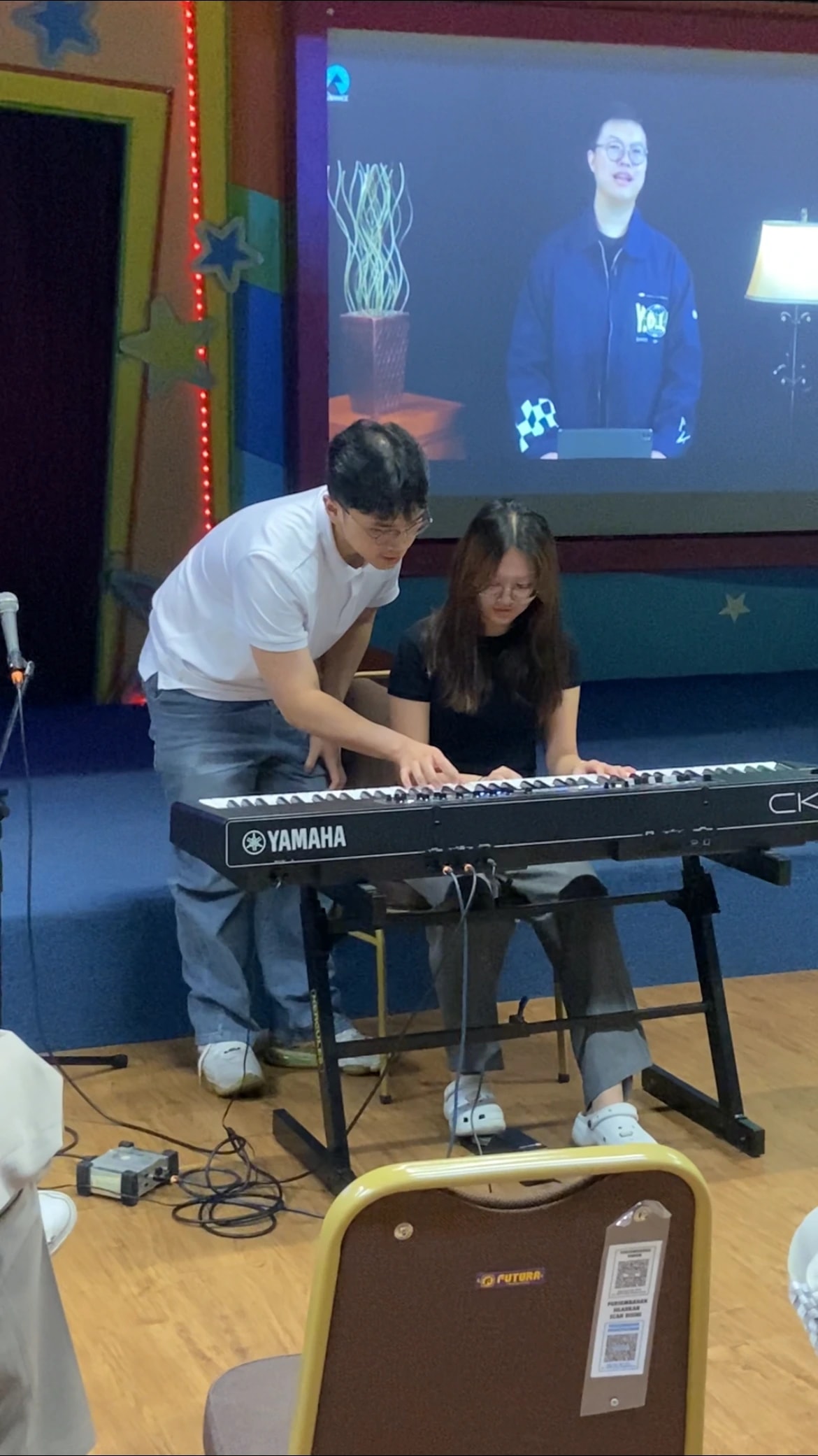 Keane guiding a student's hand position during a live lesson