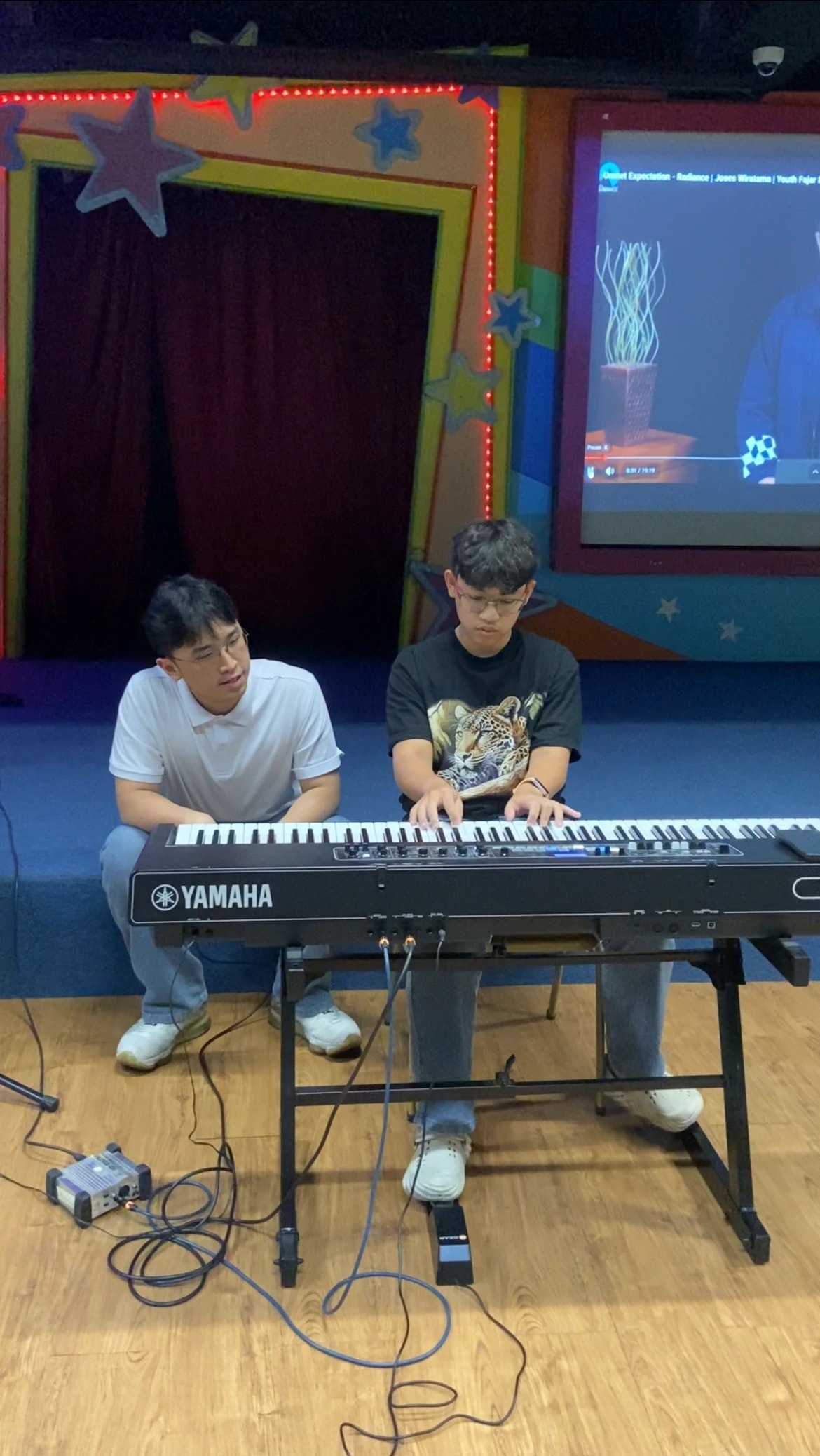 A student playing through a passage while Keane listens